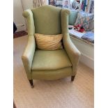 An upholstered wing armchair, late 19th century, with padded back, arms and seat and on square