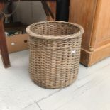A wicker log basket. (Dimensions: Height 50cm, diameter 51cm)(Height 50cm, diameter 51cm)