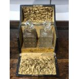 A Victorian leather covered decanter box, enclosing a pair of cut glass decanters with stoppers. (