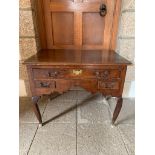 A George III oak lowboy, the rectangular moulded top above three drawers and a shaped apron, on
