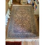 A Persian Ghom rug, the madder field with a central lobed medallion with scrolling vines and leaves,