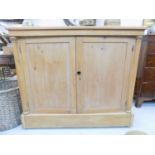 A late Victorian pine cupboard, with a pair of panelled doors flanked by turned columns on a