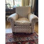 An upholstered armchair, with red and green floral upholstery, on bun feet. (Dimensions: Height