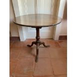 A George III mahogany tripod table, with bird cage action, on a baluster stem, on downswept cabriole