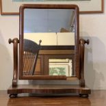 A mahogany bow front dressing table mirror, early 19th century, with three drawers and bun feet. (