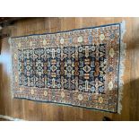 An Indian rug of Perepedil design, the indigo field with ram's horn guls and stylised birds,