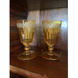 A pair of cut glass rummers, each yellow flashed and with an engraved floral band. (Dimensions: