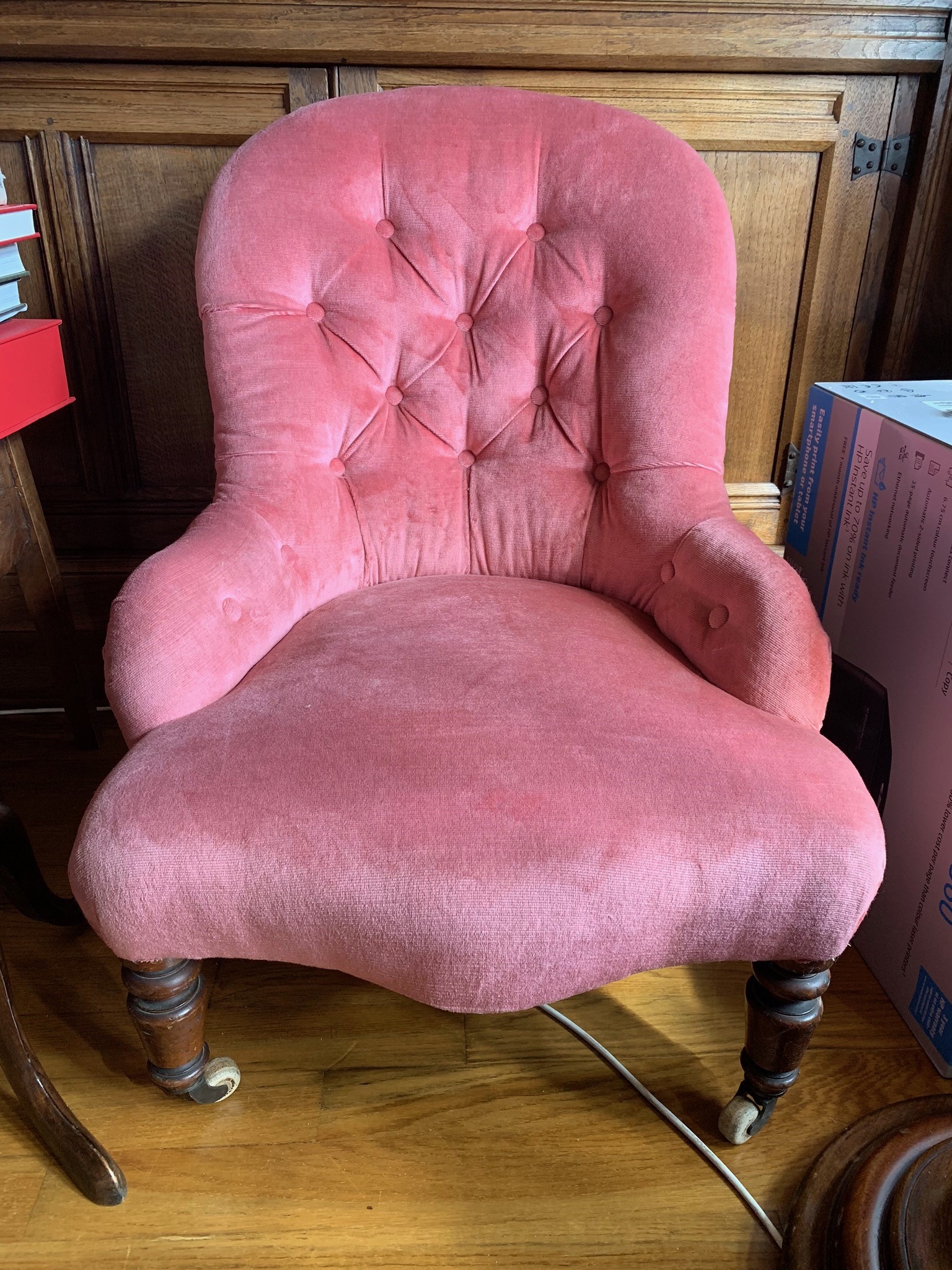 A Victorian upholstered tub armchair with turned tapering legs. (Dimensions: Height 81cm)(Height