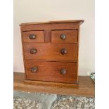 A miniature mahogany chest of drawers. (Dimensions: Height 20cm, width 19.5cm)(Height 20cm, width