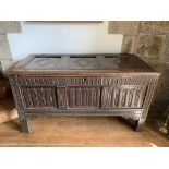 A carved oak coffer, 17th century, the triple panelled top with lozenge motifs above a carved front.