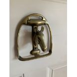 A brass door knocker in the form of a horse's head within a stirrup. (Dimensions: Height 12cm, width