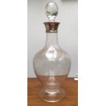 A silver rimmed glass decanter and other glassware.