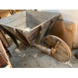 A massive wooden wheelbarrow with solid wooden wheel.