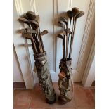 A collection of old golf clubs, including woods and irons, in two canvas bags.