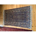 A Belouch rug, the central mihrab filled with hooked guls and linked lozenge motifs within three