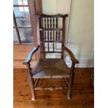 An ash and elm spindle back armchair, 19th century, with a rush seat. (Dimensions: Height 105cm.)(