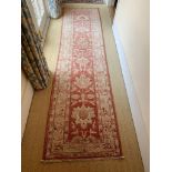 A Ziegler design runner, the red ground with palmettes and flowering vines. (Dimensions: 291.5cm x