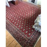 A Pakistan carpet, the red ground with multiple rows of guls. (Dimensions: 405cm x 308cm)(405cm x