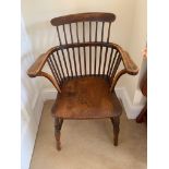 An ash and elm stick filled Windsor armchair, the dished seat on turned tapering legs. (