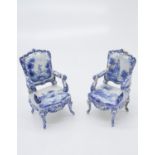 A pair of tin glazed earthenware chairs,decorated in the Delft manner with figures and rural