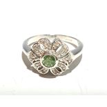 A diamond and peridot bow set white gold ring.