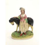 A Victorian Staffordshire figure of a girl with a donkey, on oval base. (Dimensions: Height 24.