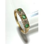 A 9ct gold ring set two diamonds and three emeralds.