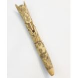 A scrimshaw walrus tusk, finely decorated with a sailor and various nautical scenes, potted flowers,