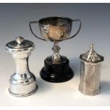 A silver pepper grinder, an engraved silver pepper and a small silver twin handled trophy.