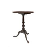 A George III mahogany tripod table, the dished snap top, on a turned and fluted baluster stem,