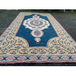 A large Savonnerie design machine made carpet, the blue ground with an ivory lobed medallion and