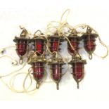 A group of eight ship's type brass lights, with domed red glass shades. (Dimensions: Each
