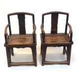 A pair of Chinese hardwood armchairs, early 19th century, the arched top rail and central vertical