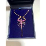 A gold and pink sapphire scorpion pendant with demantoid garnet eyes on gold chain. (Qty: 1)