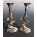 A pair of silver plated spill vases, each decorated with fruiting vines and a grouse. (Dimensions: