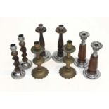 A pair of brass candlesticks, height 19.5cm, together with three pairs of treen candlesticks.