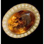 A citrine oval gold brooch, the faceted stone within a band of pearls