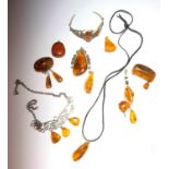 An amber and silver necklace, six amber pendants, two amber brooches, an amber bracelet and two