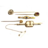 Three gold stick pins, a gold bar brooch set with a cameo and one other bar brooch.