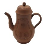 An 18th century Elers Brothers red stoneware coffee pot and cover decorated with applied oriental