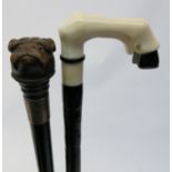 A Victorian ebonised walking cane, the carved wood knop in the form of a dog, together with