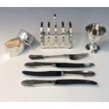 A silver toast rack, a silver egg cup, two silver napkin rings, a Victorian silver fork, 6oz,