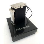 A Yves Saint Laurent cigarette holder with integral lighter in original box.