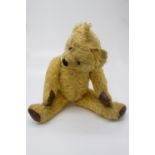 An early 20th century articulated teddy bear with leather pads. (Dimensions: Height 56cm.)(Height