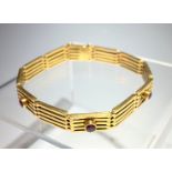 An 18ct gold gatelink bracelet set five rubies, 22.7g, boxed.