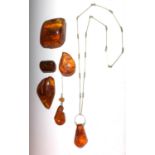 An amber necklace, an amber brooch and four pieces of amber, largest 7.2 x 6 x 2.4cm.