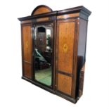 A Edwardian mahogany and satinwood triple wardrobe, the dentil cornice above a central mirrored door