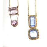 Two gold necklaces one with a pair of pale amethyst the other with a pair of pale blue stones.