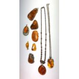 Two amber necklaces, five amber pendants, largest length 6.2cm, an amber brooch, length 5cm and a