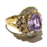 An 18ct gold costume ring set a central amethyst surrounded by pave set and single diamonds.
